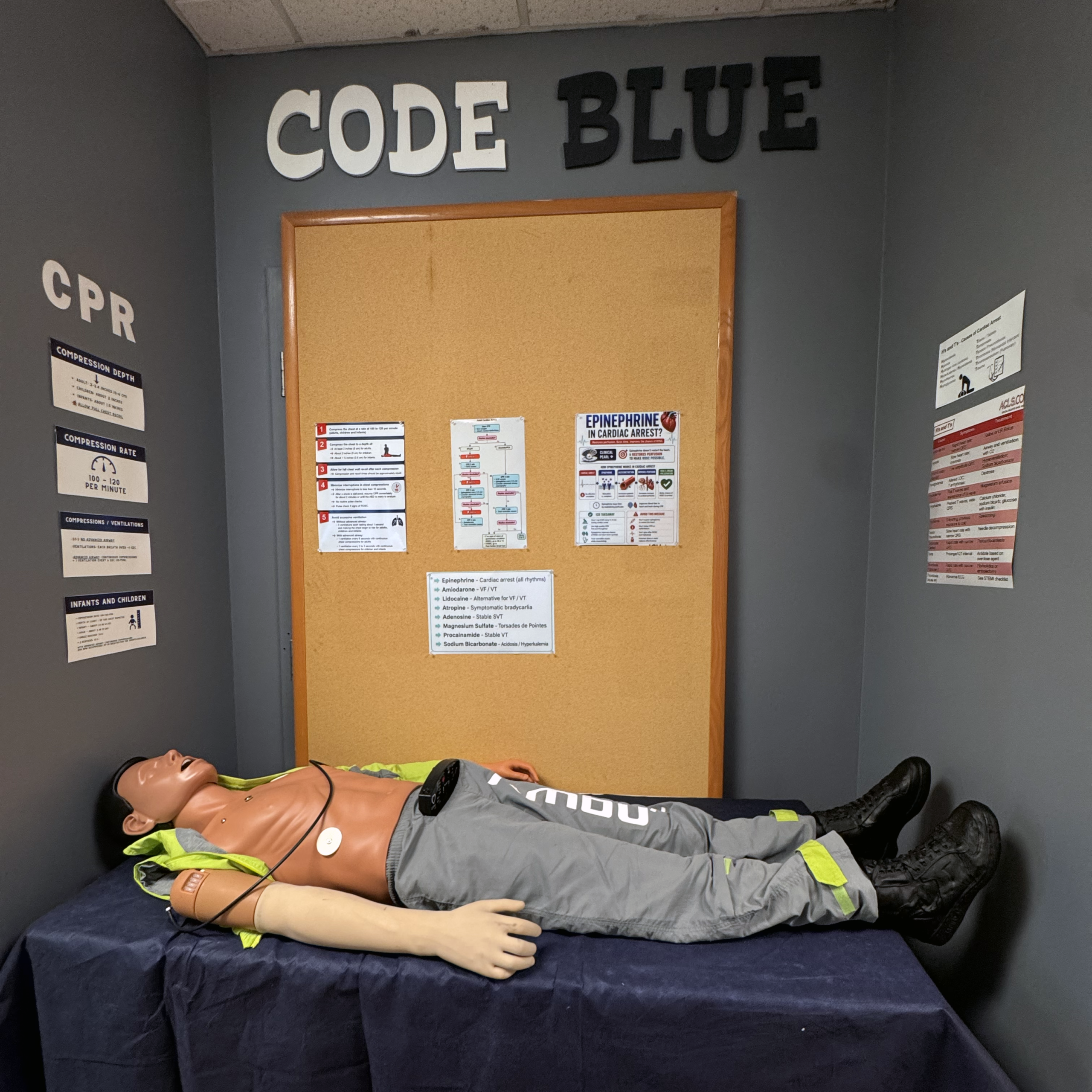 Full-body patient simulation mannequin on a treatment table in MTSU’s EMT training space.