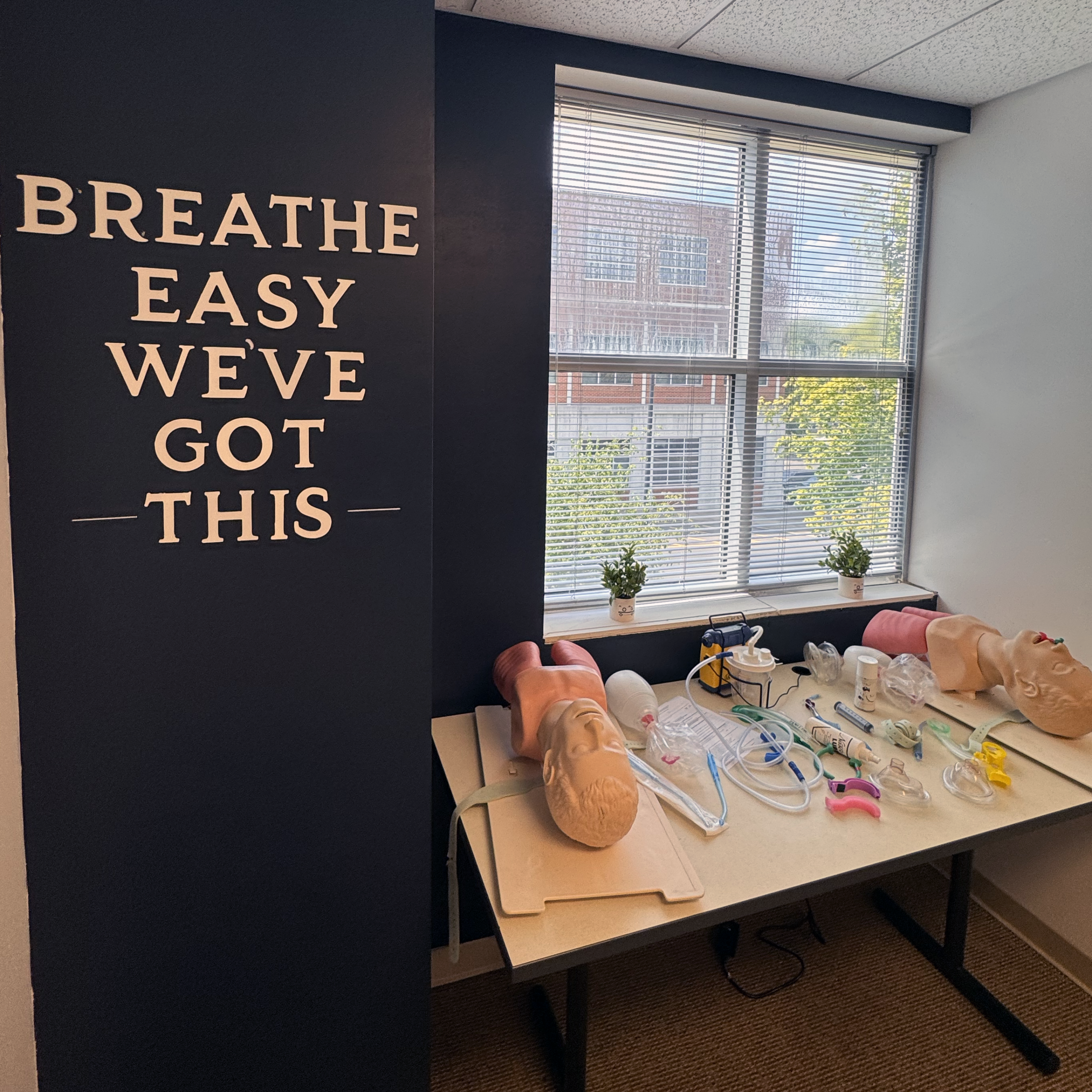 Airway training mannequins and medical equipment arranged on a table in MTSU’s EMT training space.